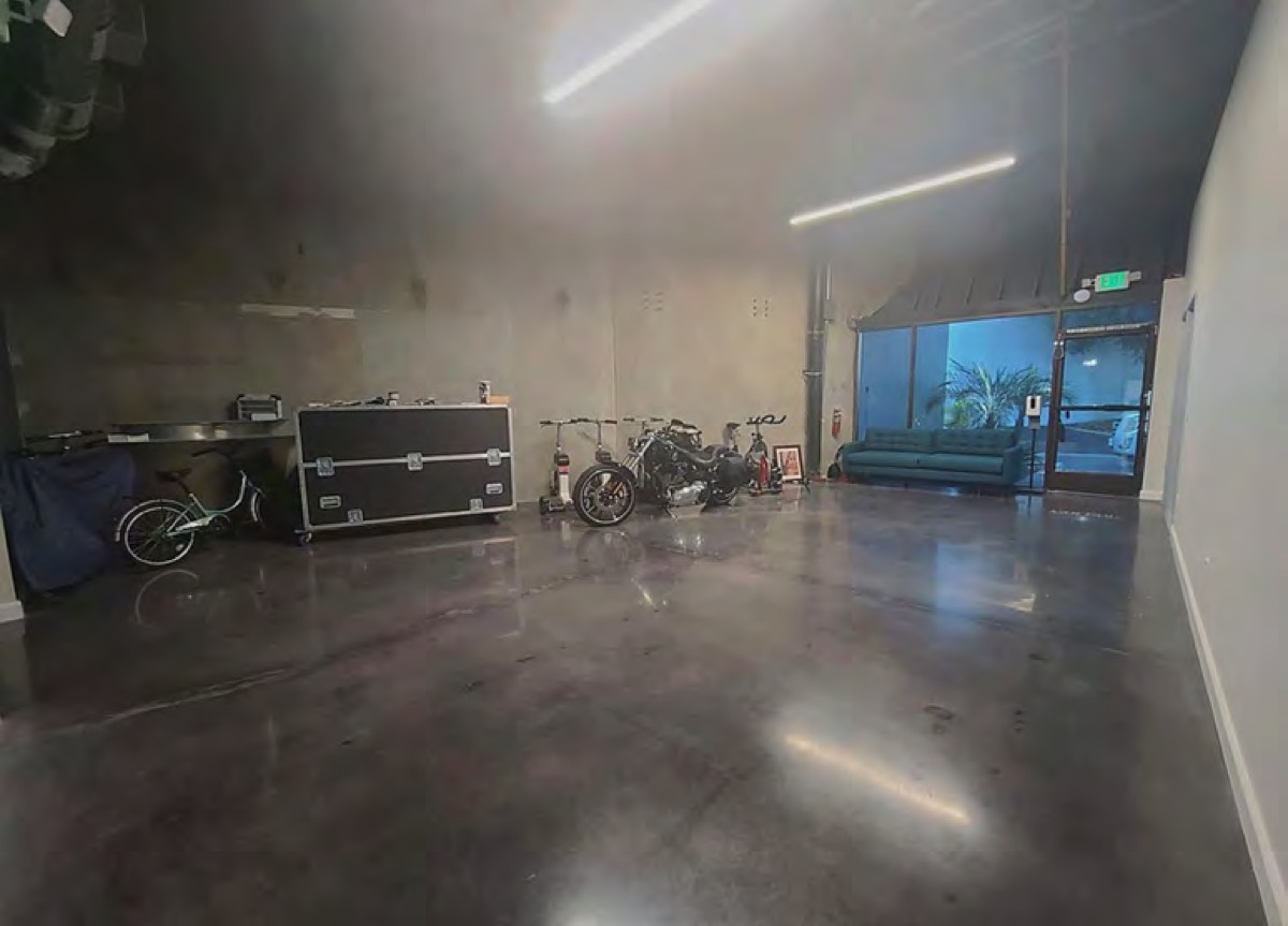 A tall bullpen with a raw cement wall and polished floor