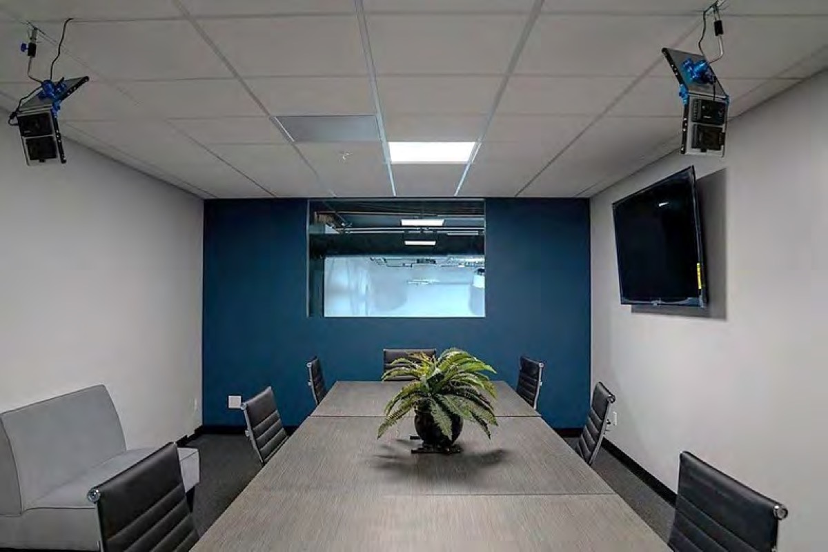 Conference room with a long table and a window onto the stage