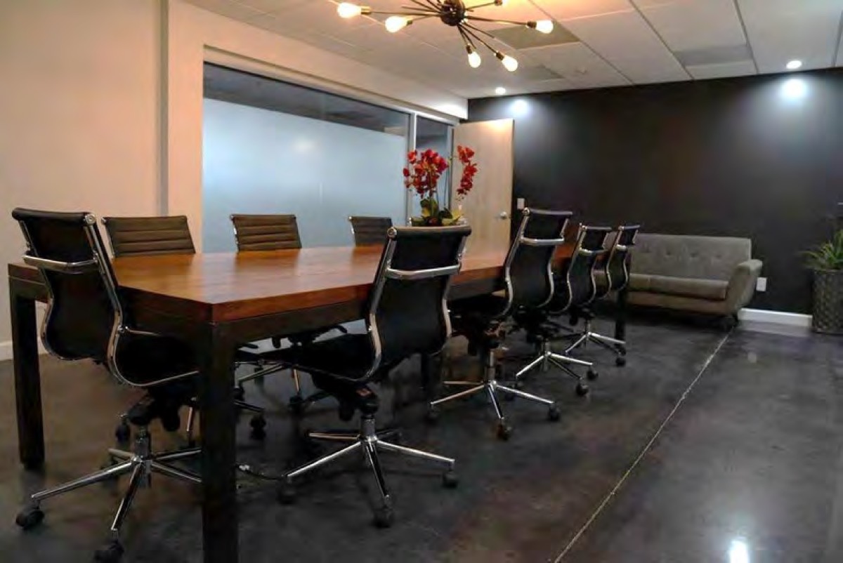 Executive conference room with a long wood table and a sputnik light