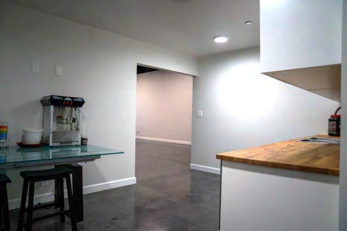 Office kitchenette with white cabinets and a popcorn machine